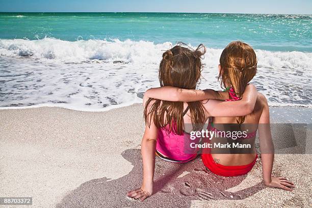 young girls sitting on the beach watching the wave - captiva island stock-fotos und bilder