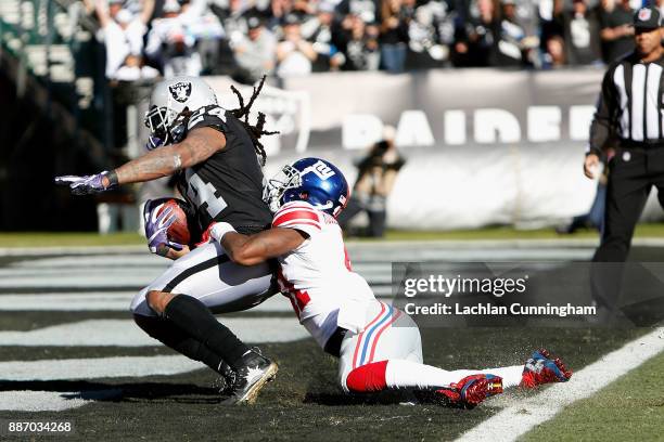 Running back Marshawn Lynch of the Oakland Raiders is tackled by Dominique Rodgers-Cromartie of the New York Giants as he scores a 51-yard touchdown...