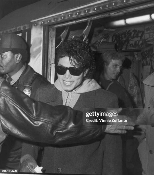 Popular American musician Michael Jackson smiles as he steps of the a subway car during the filming of the long-form music video for his song 'Bad,'...