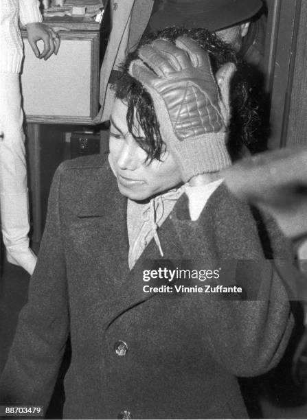 Popular American musician Michael Jackson stands with a gloved hand on his head during the filming of the long-form music video for his song 'Bad,'...