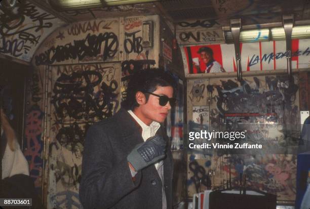 Popular American musician Michael Jackson stands in a graffiti-filled subway car during the filming of the long-form music video for his song 'Bad,'...