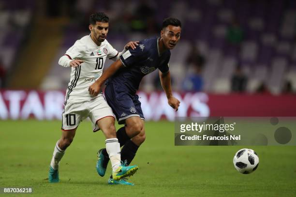 Takuya Iwata of Auckland City FC is challenged by Mbark Boussoufa of Al-Jazira during the FIFA Club World Cup UAE 2017 play off match between Al...
