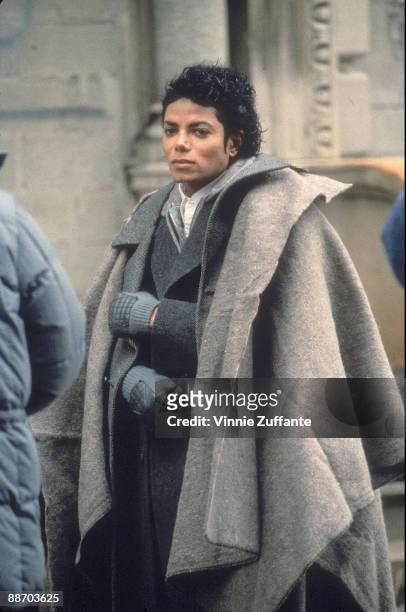 Popular American musician Michael Jackson stands with a blanket over his shoulders during a break in the filming of the long-form music video for his...