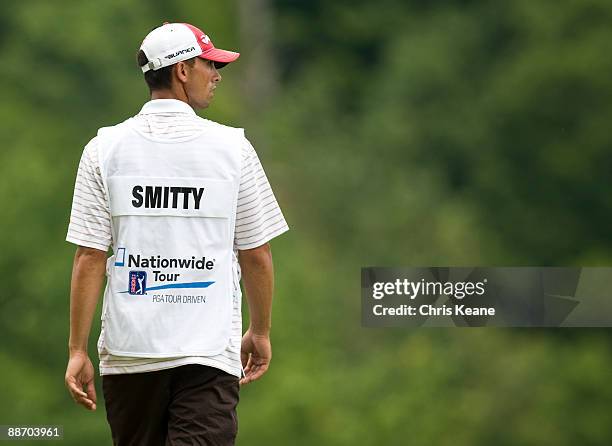 Caddie Trey Bilardello watches players on the first hole while displaying the name 'Smitty' on the back of his bib in tribute to player Chris Smith...