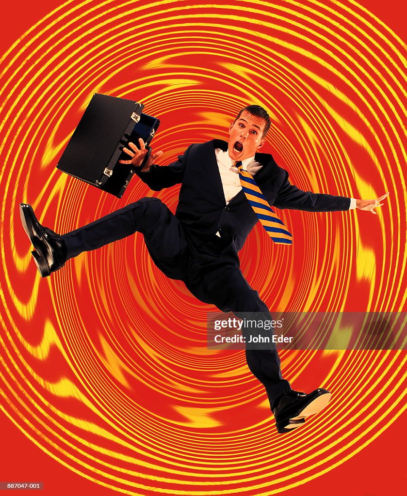 Businessman with briefcase falling into whirlpool (Digital Composite)