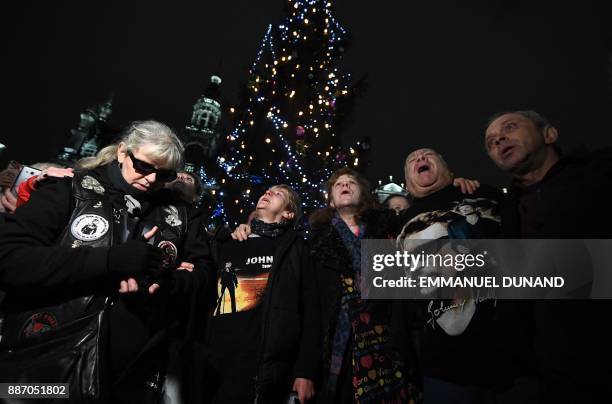 Fans of late French rock star Johnny Hallyday pay their respects after the death of the singer on the Grand Place in Brussels on December 6, 2017....