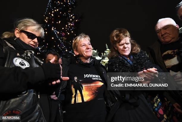 Fans of late French rock star Johnny Hallyday hold candles as they pay their respects after the death of the singer on the Grand Place in Brussels on...