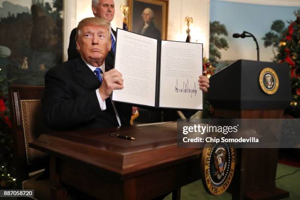 President Donald Trump holds up a proclaimation that the U.S. Government will formally recognize Jerusalem as the capital of Israel after signing the...