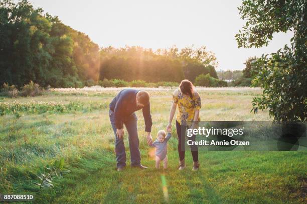 young family walking together - learning to walk stockfoto's en -beelden