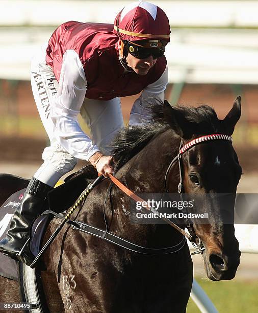 Jockey Peter Mertens riding Denman wins Race One the SMS Scaffolding Handicap during National Jockey Celebration Day on June 27, 2009 in Melbourne,...