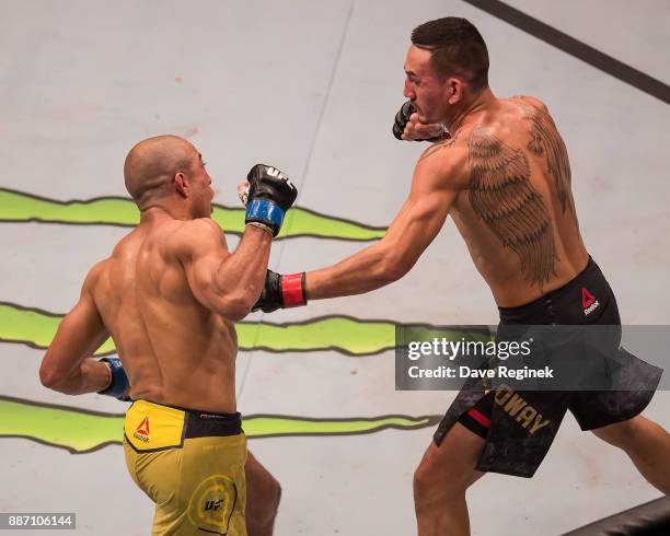 Jose Aldo fights Max Holloway during a UFC bout at Little Caesars Arena on December 2, 2017 in Detroit, Michigan. Holloway defeated Aldo with a TKO...