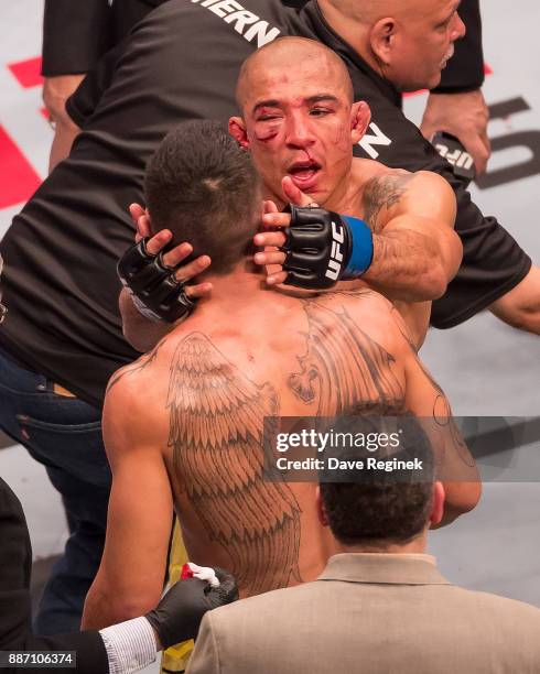 Jose Aldo hugs Max Holloway after a UFC bout at Little Caesars Arena on December 2, 2017 in Detroit, Michigan. Holloway defeated Aldo with a TKO in...