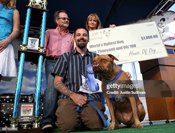 Miles Egstad of Citrus Heights, California, stands with his dog Pabst, a boxer mix, after winning the 21st Annual World's Ugliest Dog Contest at the...