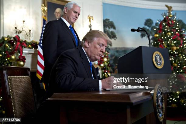 President Donald Trump signs a proclamation next to U.S. Vice President Mike Pence, left, after making a statement on Jerusalem in the Diplomatic...