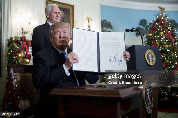 President Donald Trump holds up a proclamation next to U.S. Vice President Mike Pence, left, after making a statement on Jerusalem in the Diplomatic...