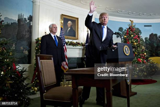 President Donald Trump waves next to U.S. Vice President Mike Pence, left, after making a statement on Jerusalem in the Diplomatic Room of the White...