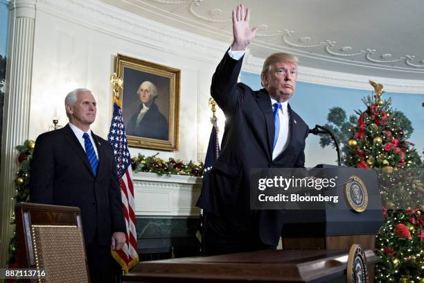 President Donald Trump waves next to U.S. Vice President Mike Pence, left, after making a statement on Jerusalem in the Diplomatic Room of the White...