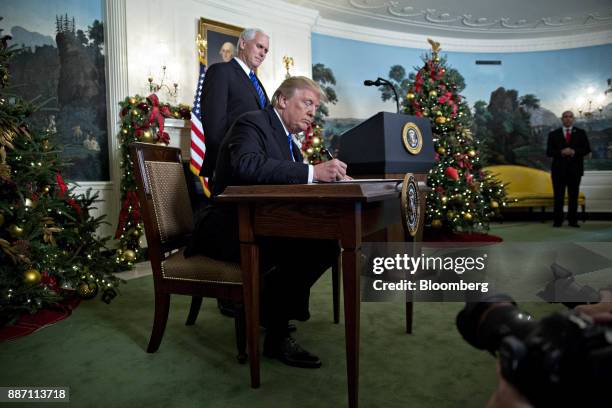 President Donald Trump signs a proclamation next to U.S. Vice President Mike Pence, left, after making a statement on Jerusalem in the Diplomatic...