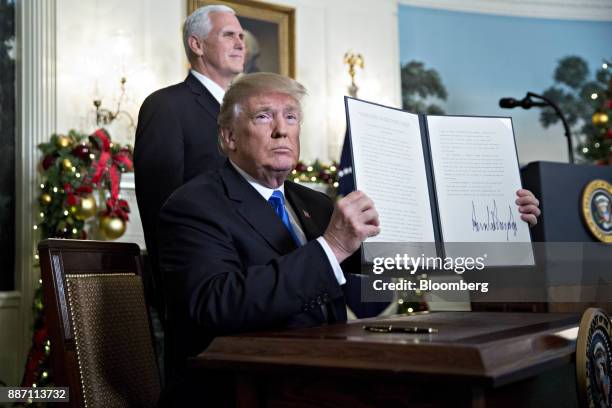 President Donald Trump holds up a proclamation next to U.S. Vice President Mike Pence, left, after making a statement on Jerusalem in the Diplomatic...