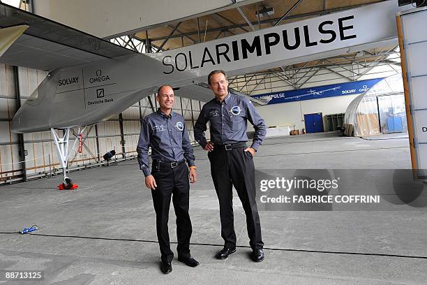 Swiss scientist-adventurer and pilot Bertrand Piccard and Solar Impulse CEO Andre Borschberg pose under the 'Solar Impulse' airplane after an...