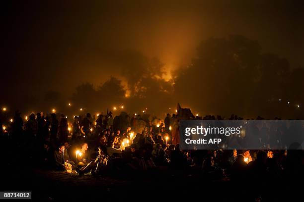 Revellers gather near the Stone Circle in the early hours of the second day of the annual Glastonbury festival near Glastonbury, Somerset on June 27,...