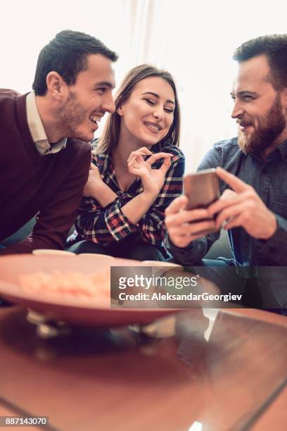 group of friend eating snacks, conversing and having fun time together - college dorm party stock pictures, royalty-free photos & images