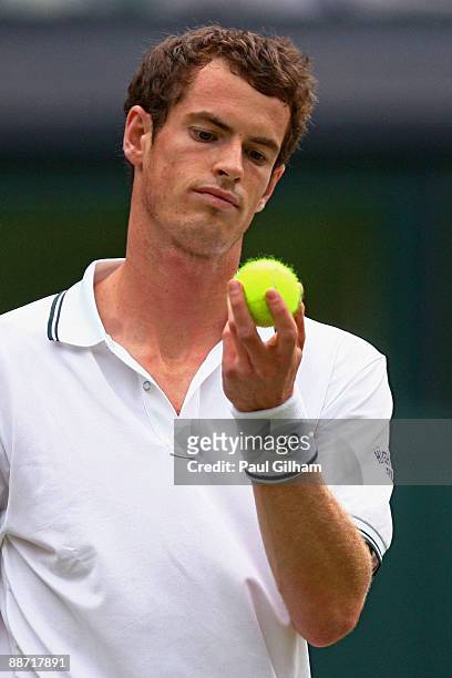 Andy Murray of Great Britain inspects a tennis ball during the men's singles third round match against Viktor Troicki of Serbia on Day Six of the...