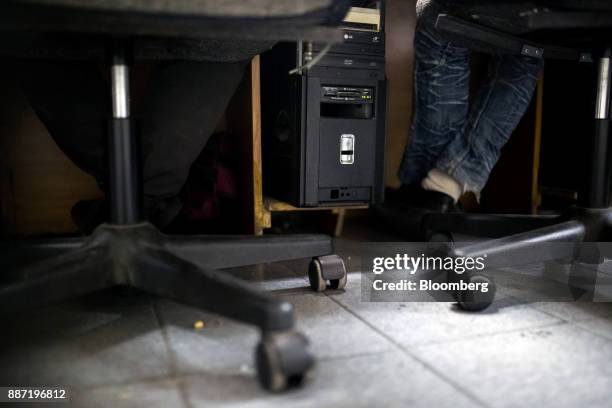 Computer tower stands between two people playing video games at a cybercafe in Caracas, Venezuela, on Tuesday, Nov. 28, 2017. Crisis-wracked...