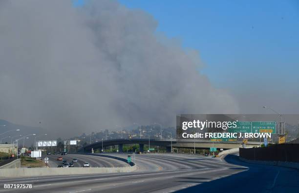 Huge plume of black smoke from Bel-Air rises east of the closed-off 405 freeway heading north on December 6, 2017 in Los Angeles, California....