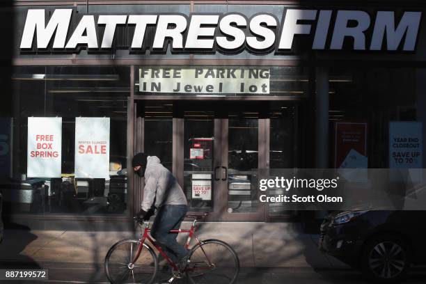 Cyclist passes a Mattress Firm store on December 6, 2017 in Chicago, Illinois. Steinhoff International Holdings N.V., which is the parent company of...