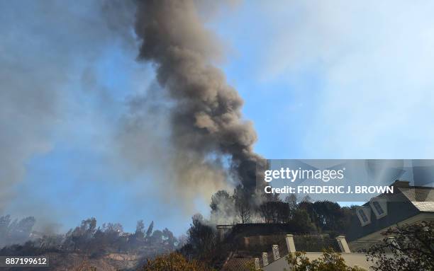 Smoke rises from burning structures on the hilltop in Bel Air, east of the 405 freeway heading north on December 6, 2017 in Los Angeles, California....