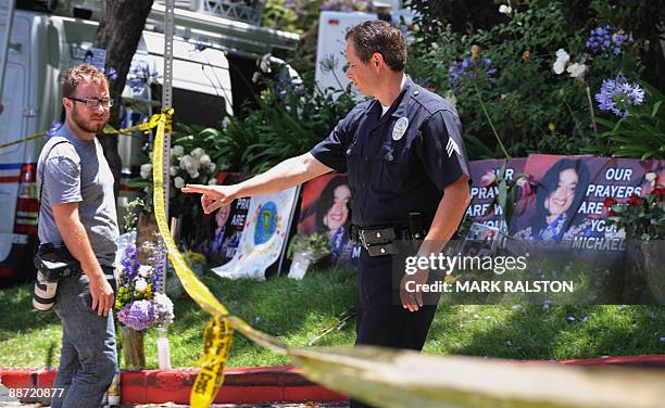 Policeman keeps order at the rented Holmby Hills home of music legend Michael Jackson after his recent death, in Los Angeles on June 27, 2009. The...
