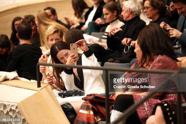 Hannah Herzsprung take a photo of Christiane Paul and Nicolette Krebitz during the Chanel "Trombinoscope" collection Metiers d'Art 2017/18 show at...