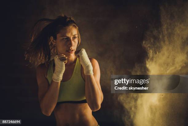 determinata donna atletica che si scalda con esercizi di boxe. - posizione di lotta foto e immagini stock