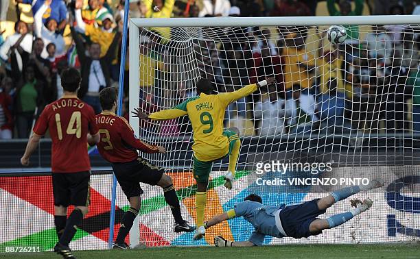 Spanish goalkeeper Iker Casillas fails to stop the goal shot by South African forward Katlego Mphela , next to Spanish midfielder Xabi Alonso and...