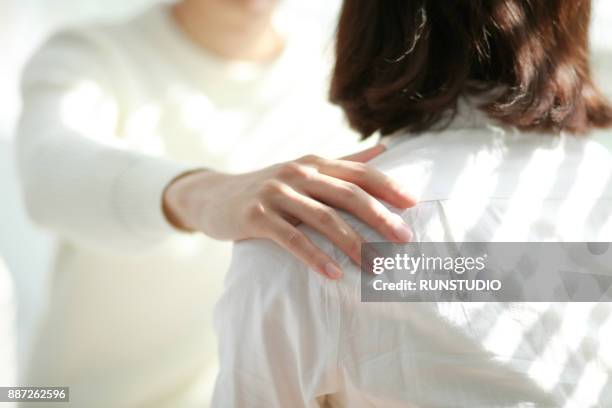 man hand on woman shoulder - straight black hair stock pictures, royalty-free photos & images