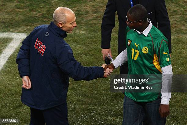 Marc-Vivien Foe's son shakes hands with USA Coach Bob Bradley after giving a speech in honour of his father who died on the pitch six years ago,...