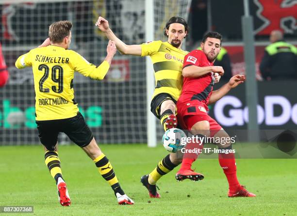 Marcel Schmelzer of Dortmund, Neven Subotic of Dortmund and Kevin Volland of Leverkusen battle for the ball during the Bundesliga match between Bayer...