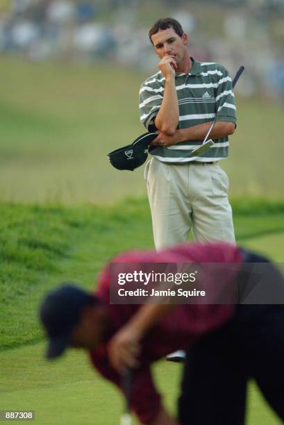 Sergio Garcia of Spain watches Tiger Woods mark his ball on the 18th green during the final round of the 102nd US Open on the Black Course at...