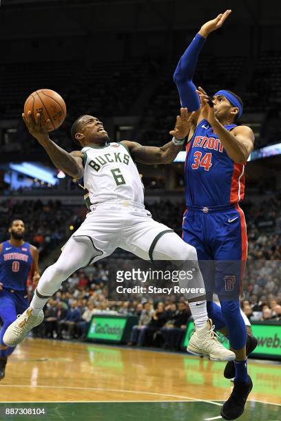 Eric Bledsoe of the Milwaukee Bucks drives to the basket against Tobias Harris of the Detroit Pistons during the first half of a game at the Bradley...