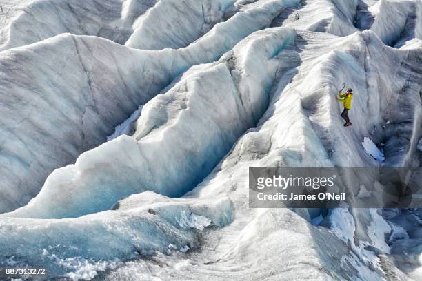 Hiker climbing ice wall in glacier, Aletsch Glacier, Switzerland