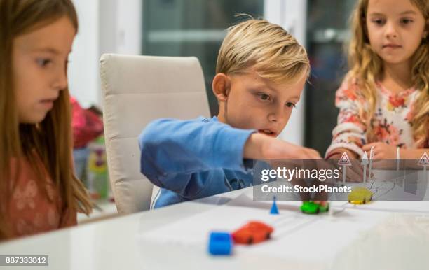 kids playing with plastic cars at the table - boy playing with cars stock pictures, royalty-free photos & images