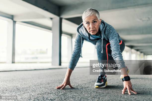 vrouwelijke atleet opleiding in de uitgangspositie - womens track stockfoto's en -beelden