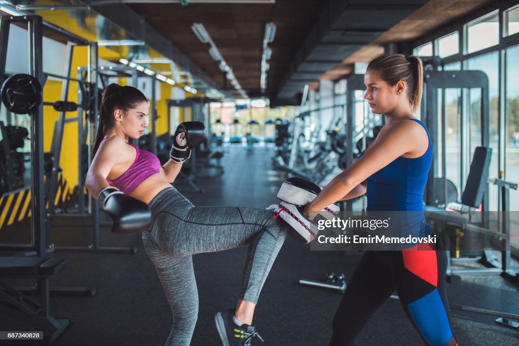 Woman doing kickboxing workout with her coach