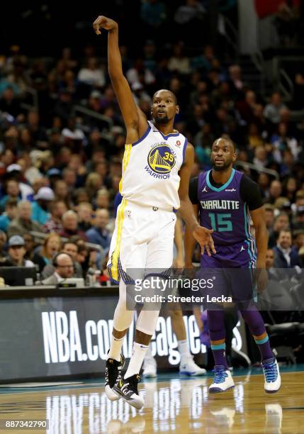 Kemba Walker of the Charlotte Hornets watches as Kevin Durant of the Golden State Warriors reacts after a shot during their game at Spectrum Center...