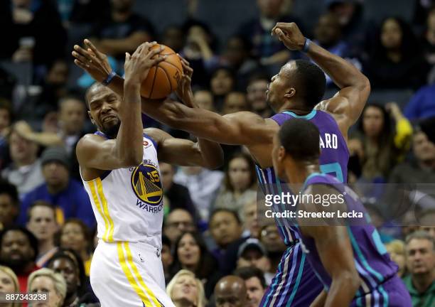 Kevin Durant of the Golden State Warriors battles for a loose ball against Dwight Howard of the Charlotte Hornets during their game at Spectrum...