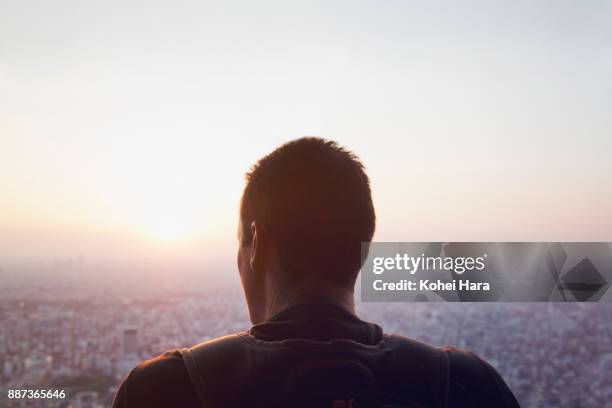 caucasian man looking down the cityscape of tokyo - gegenlicht stadt stock-fotos und bilder