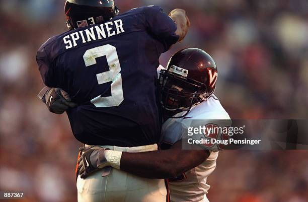 Defensive end Cols Colas of the Virginia Tech Hokies hits quarterback Bryson Spinner of the University of Virginia Cavaliers during the NCAA football...