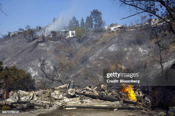 Flames burn from a destroyed home's natural gas line during the Skirball Fire in the Bel Air neighborhood of Los Angeles, California, U.S., on...