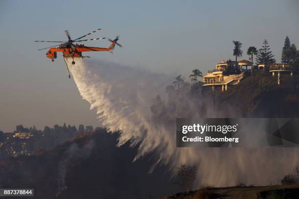 An Erickson Inc. Air Crane firefighting helicopter makes a water drop during the Skirball Fire in the Bel Air neighborhood of Los Angeles,...